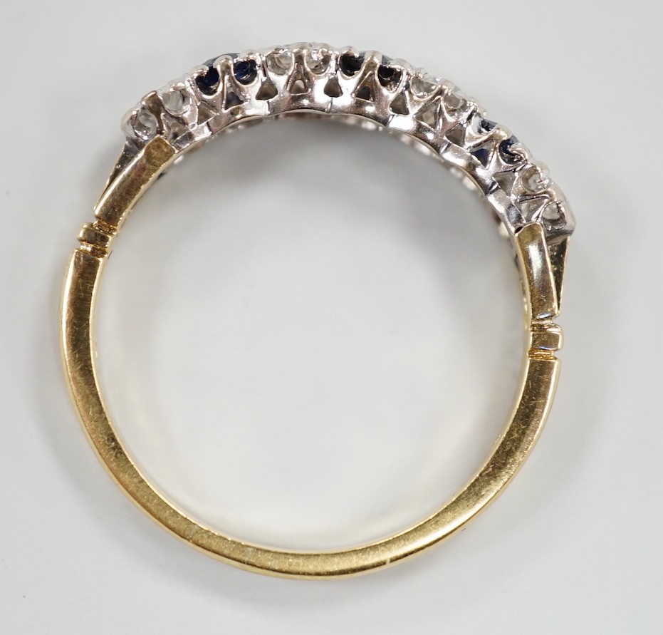 A modern 18ct gold, three stone sapphire and four stone diamond set half hoop ring, size P/Q, gross weight 2.9 grams.